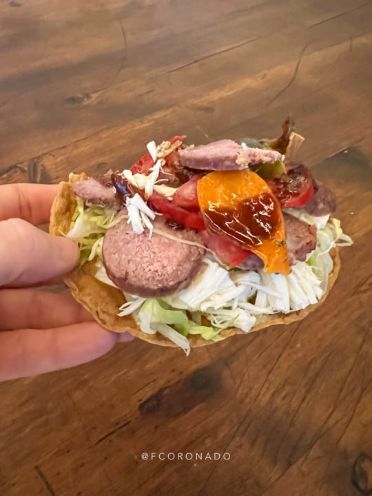 tostada de salchicha ejuteca con lechuga, tomate y chiles