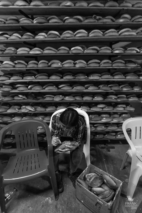 mujer decorando pan de muerto