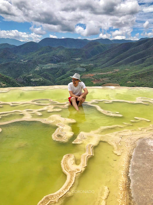 hombre sentado en una poza de hierve el agua